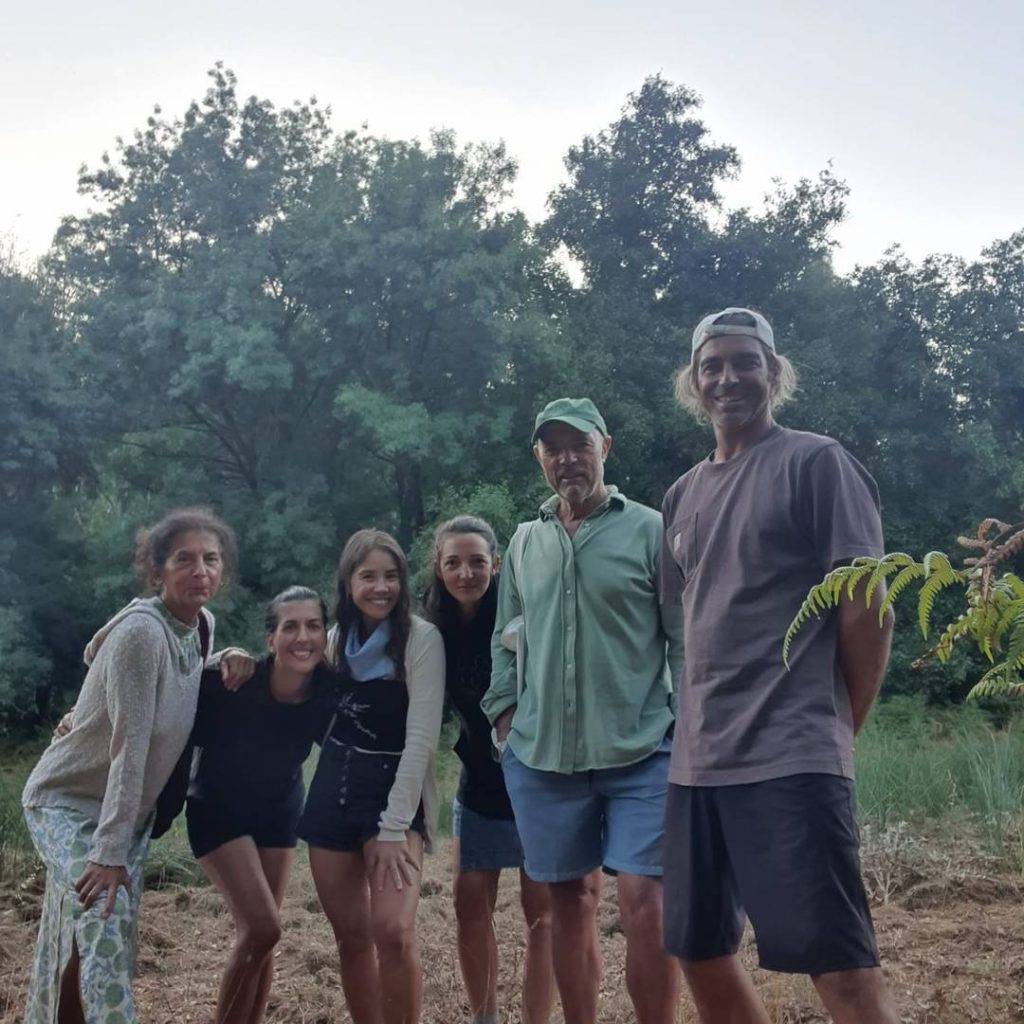 A group of yogi friends posing for a photo amidst a forest wilderness.